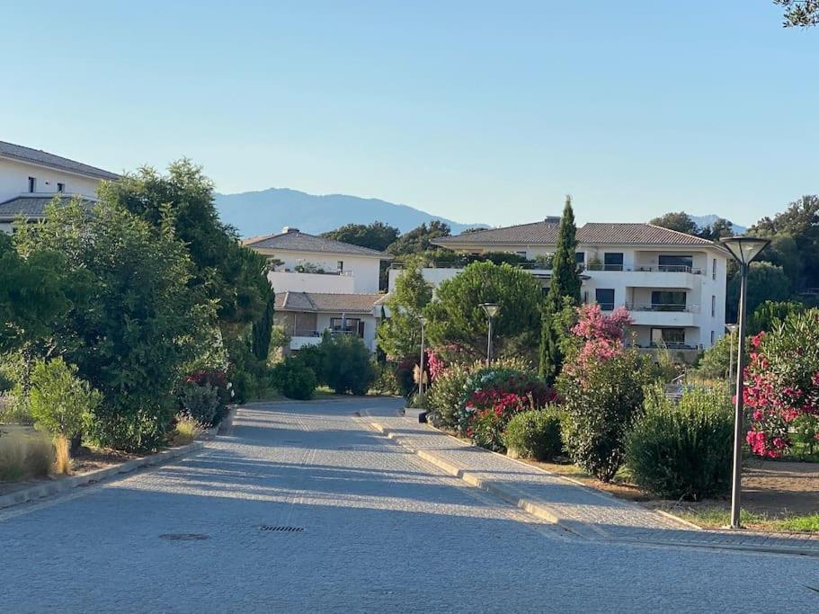 Une rue vide dans une ville avec des maisons et des fleurs dans l'établissement Domaine Arca appartement 6 à 8 Personnes, à Porto-Vecchio