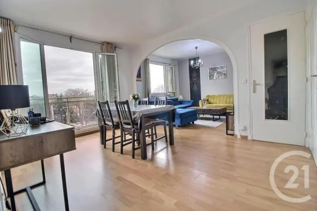 uma sala de jantar e sala de estar com mesa e cadeiras em Très charmant appartement proche de Paris em Aulnay-sous-Bois