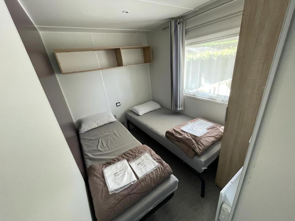 a small room with two beds and a window at Grand Mobil Home in Houlgate