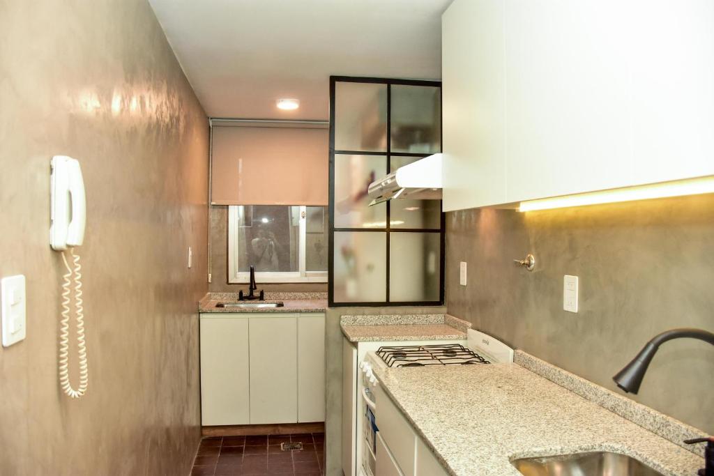 a kitchen with a sink and a stove at DEPARTAMENTO PEATONAL SARMIENTO PLENO CENTRO MENDOZA 3-4 Personas, Con Cochera GRATIS ! in Mendoza