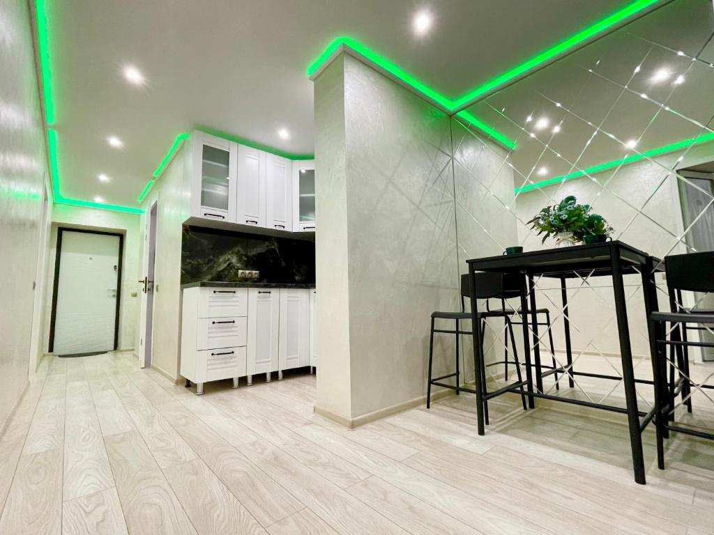 een keuken met groene verlichting op het plafond bij Brand new apartment Chisinau not far from the airport in Chişinău