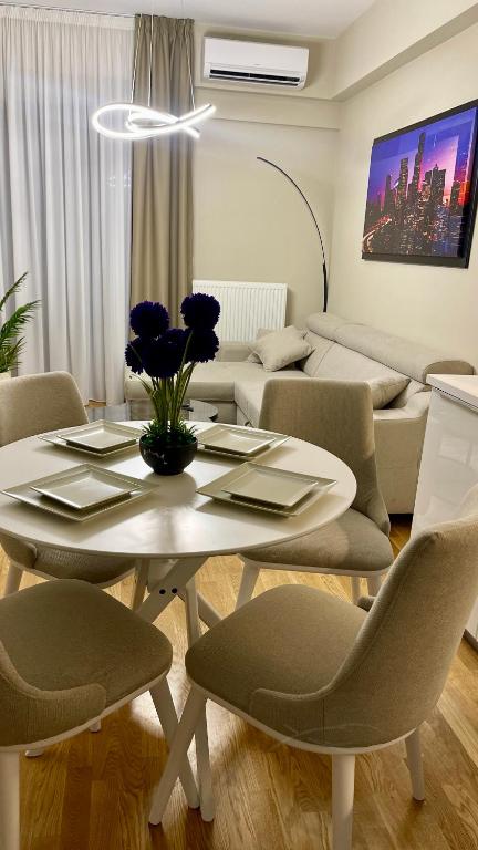 uma sala de estar com uma mesa, cadeiras e um sofá em Diamond of Skopje Luxury apartment 18th floor em Skopje