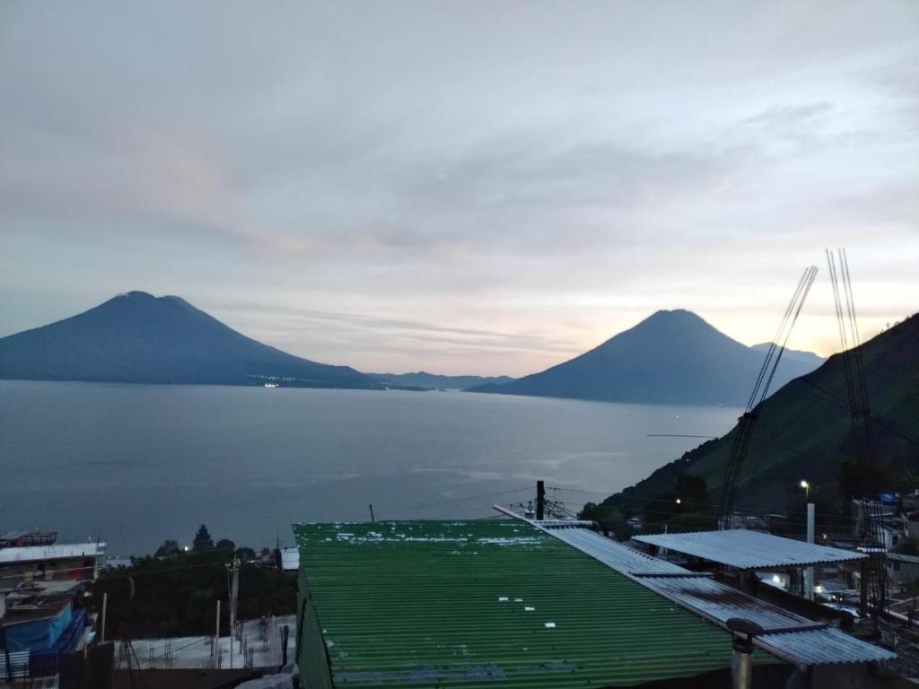 vista su una grande pozza d'acqua con montagne di Posada Del Viajero - Mayan Travelers Inn a Santa Cruz La Laguna