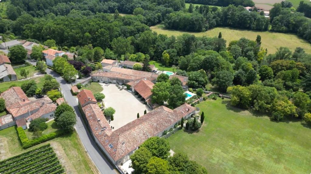 an aerial view of a house with a field and trees at Logis du paradis in Criteuil-la-Magdeleine
