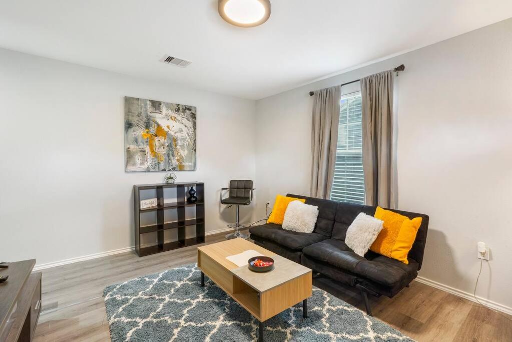sala de estar con sofá negro y mesa en Cozy Two Bedroom Home Minutes from Downtown! en Houston