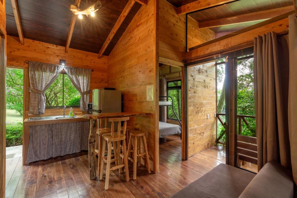 Cabaña de madera con cocina y sala de estar en Cabaña El Manzano: Vistas increíbles y Mirador, en Turrialba