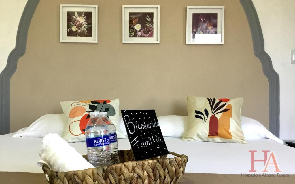 a bed with a basket with a bottle of water on it at Hospedaje Aldana - Casa LA VISTA en zona verde in Tuxpan de Rodríguez Cano