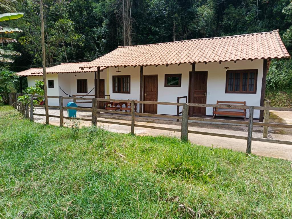 una piccola casa con una recinzione di fronte di Fazenda Piloes a Itaipava