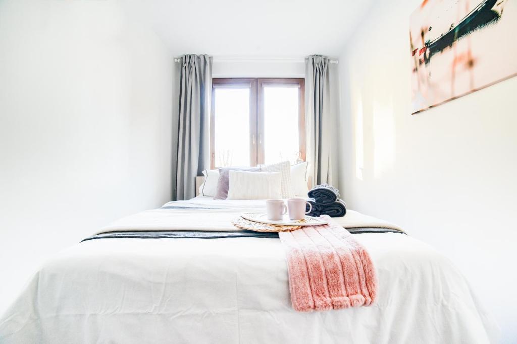 Dormitorio blanco con cama y bandeja en Oliwkowa Perła, en Władysławowo