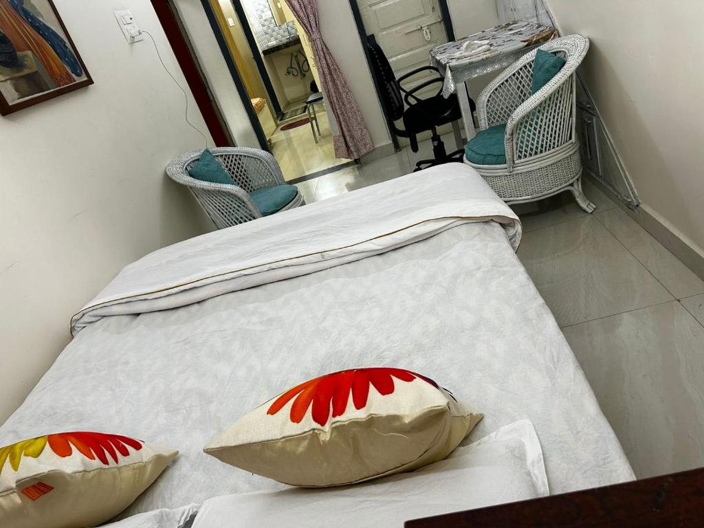 two twin beds in a room with chairs at Varsha's Villa A Luxurious Stay. in Nagpur