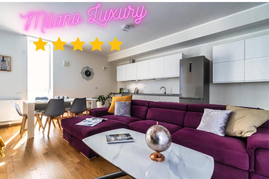 a living room with a purple couch and a kitchen at [5 min walk from subway] Elegant & Modern in Milan
