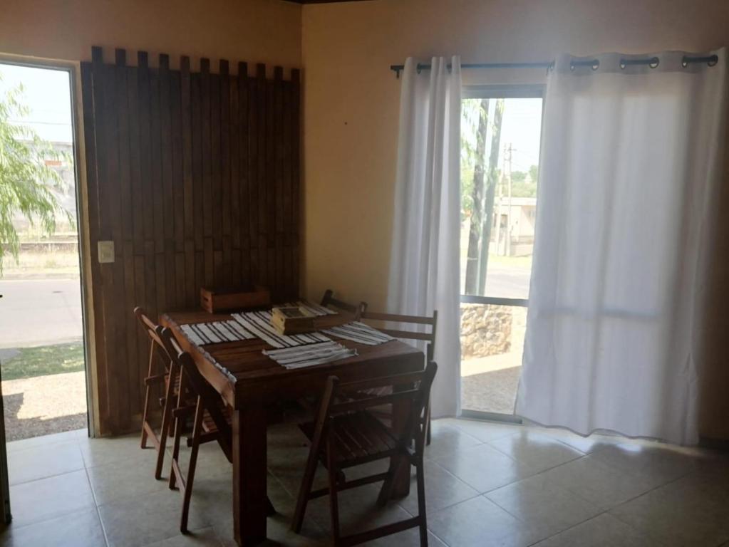 a dining room with a table and chairs and a window at Apartamento paysandu in Paysandú