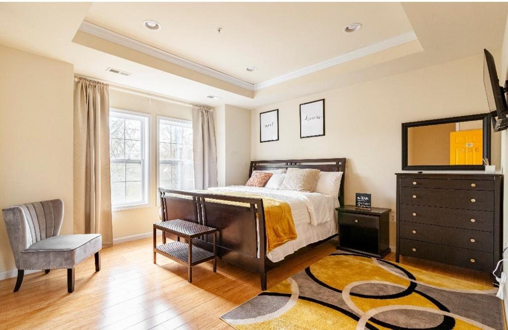 a bedroom with a bed and a television and a chair at Luxurious and Cozy Room in Washington DC in Washington