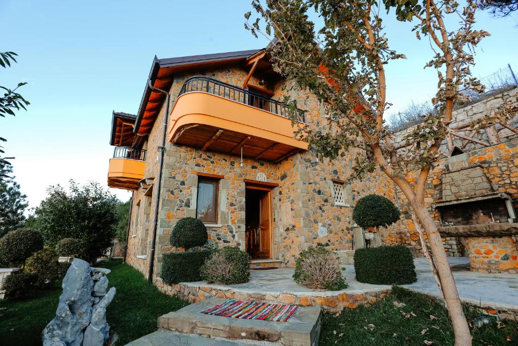 a stone house with a balcony on top of it at Shtepia Tradites Gjinar in Elbasan