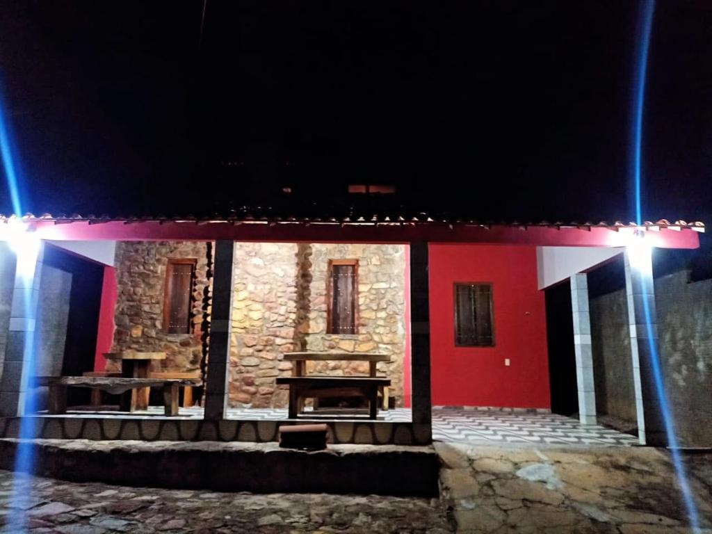 a house with a wooden table in front of it at Chalé Triunfo in Triunfo