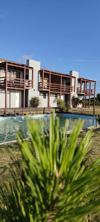 a building with a swimming pool in front of a house at Serena Aparts in La Paloma