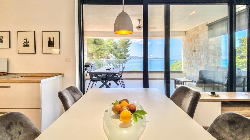 a kitchen and dining room with a table with fruit on it at Nautilus-Bay Apartments - Exklusive Suite in erster Reihe - Suite 320 in Zavala