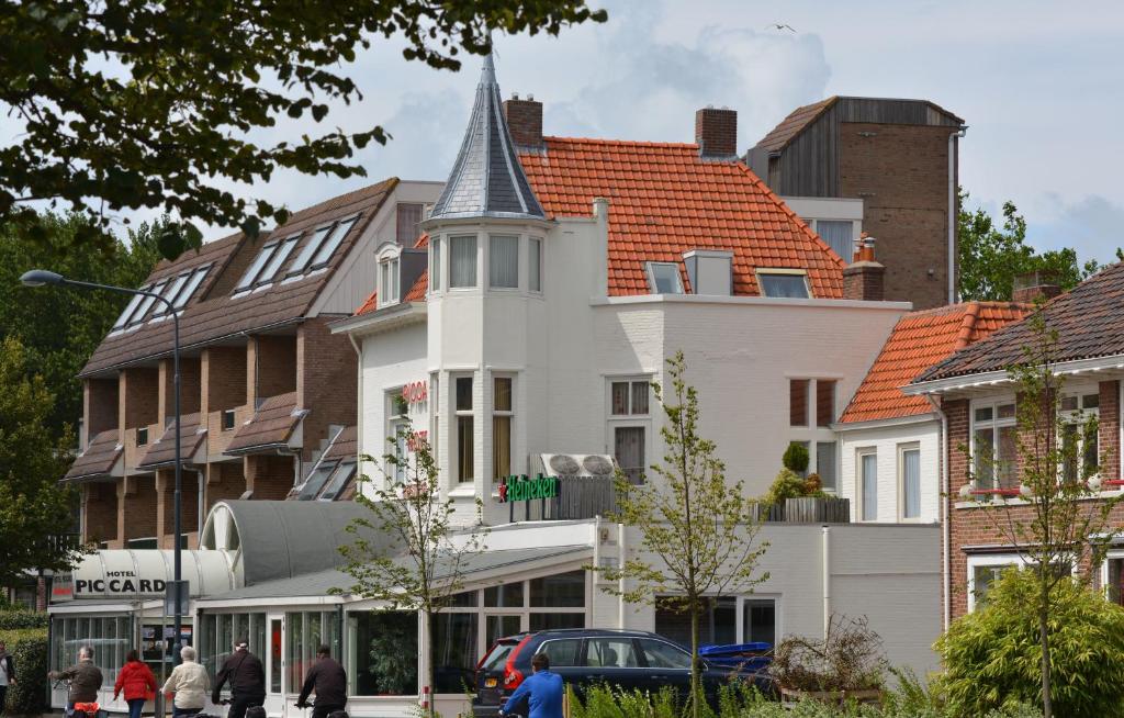 ein weißes Gebäude mit einem spitzen Turm auf einer Stadtstraße in der Unterkunft Hotel Restaurant Piccard in Vlissingen