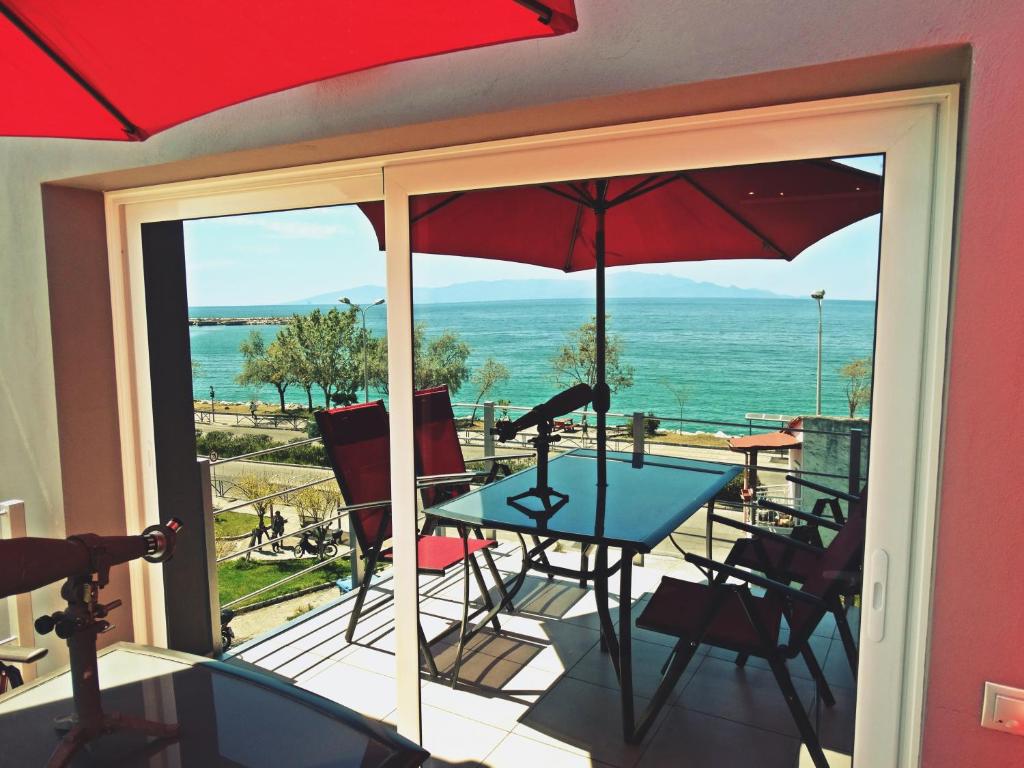 een balkon met een tafel en stoelen en uitzicht op de oceaan bij Casa Del Mare in Kavala