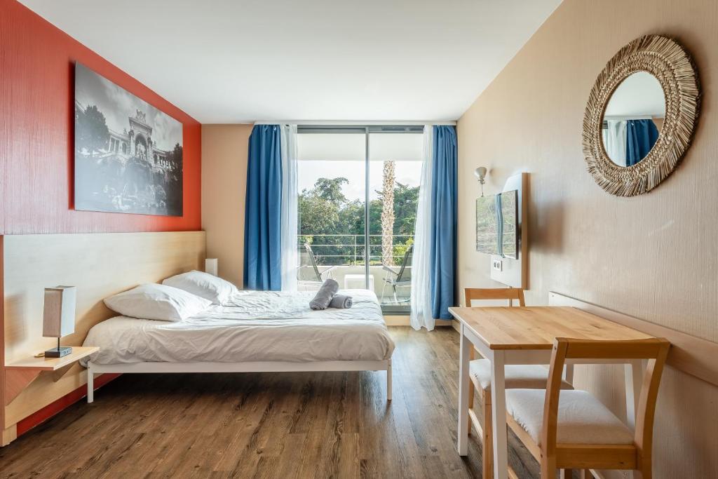 Un dormitorio con una cama y una mesa y una ventana. en Bord de mer! Studio Terrasse ,Prado Plage, en Marsella