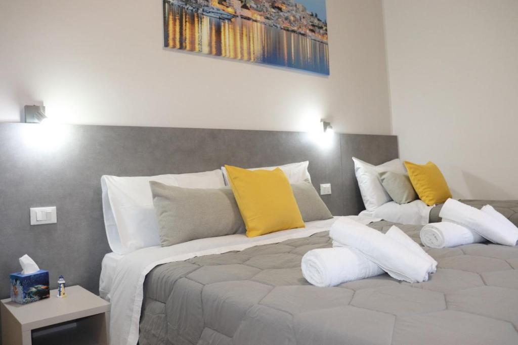 a bedroom with a large bed with yellow and white pillows at Casa Lu Mari in Sciacca