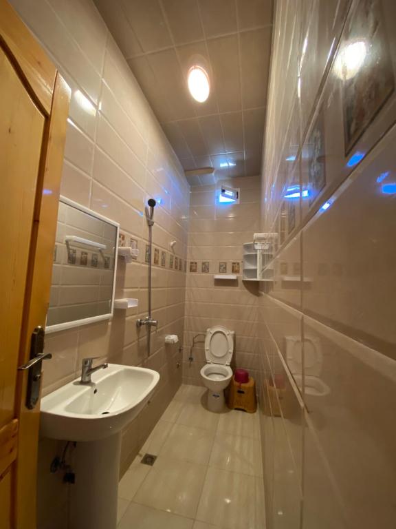 La salle de bains est pourvue d'un lavabo et de toilettes avec des lumières bleues. dans l'établissement La casa wadie 3, à Sidi Ifni