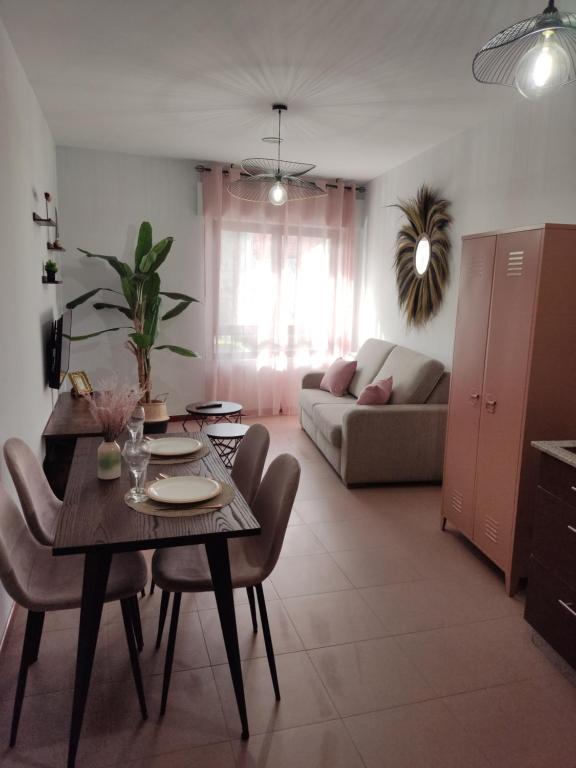 ein Wohnzimmer mit einem Tisch, Stühlen und einem Sofa in der Unterkunft Portosin Lar in Goyanes
