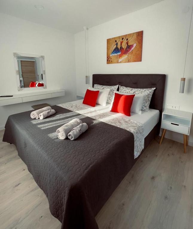 a bedroom with a large bed with red and white pillows at Apartment Lantana Hvar in Hvar