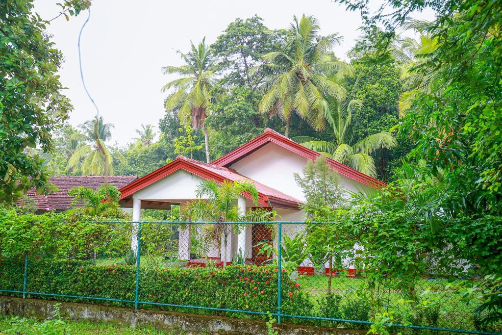 mały dom z płotem przed nim w obiekcie Villa Ravichini w mieście Polonnaruwa