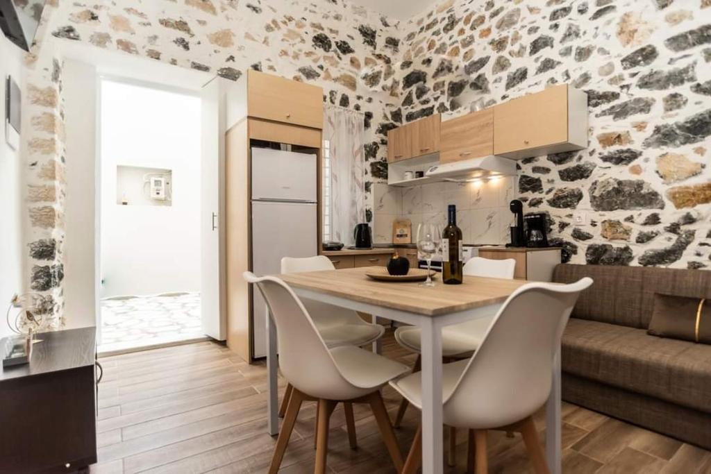 カリムノスにあるCity stone houses kalymnos 2のテーブルと椅子のあるキッチンとダイニングルーム