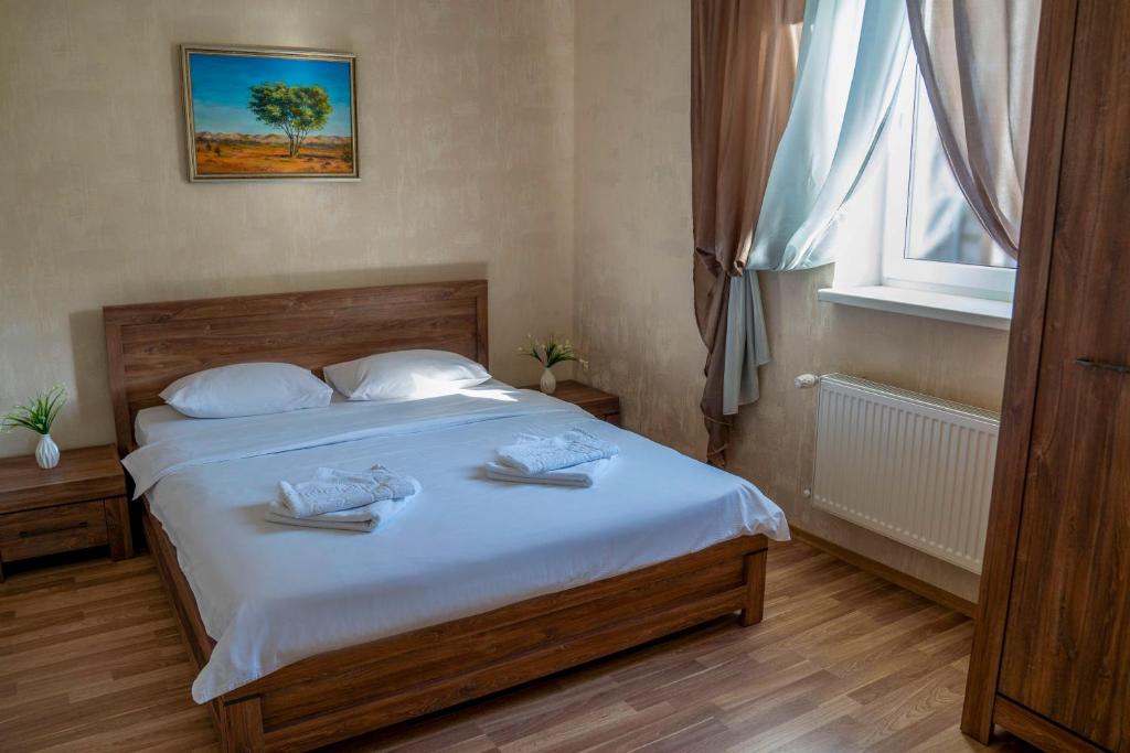 een slaapkamer met een bed met witte lakens en een raam bij Guest house Kiev forest in Kiev