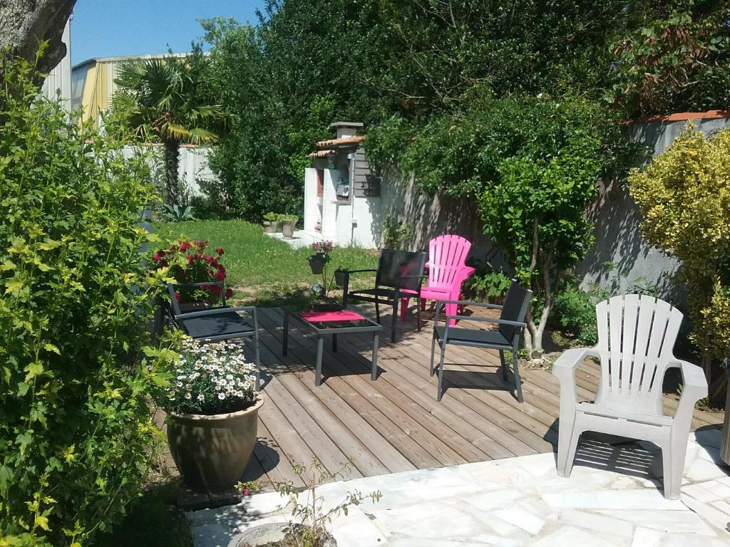une terrasse en bois avec deux chaises et quelques buissons dans l'établissement La roseraie, à Aytré