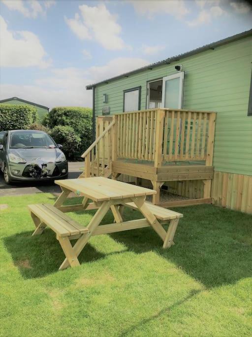 a wooden picnic table in front of a house at Georgia Lodge in Knaresborough