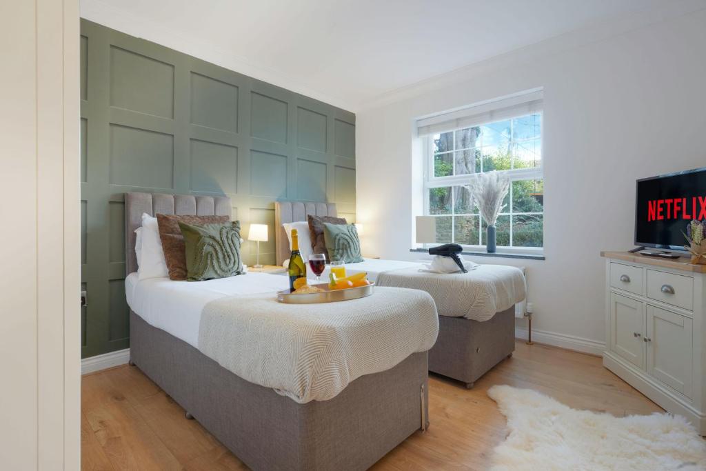 a bedroom with two beds and a tv in it at Avenue Apartment - Close to City Centre - Free Parking, Super-Fast Wifi and Smart TV by Yoko Property in Northampton