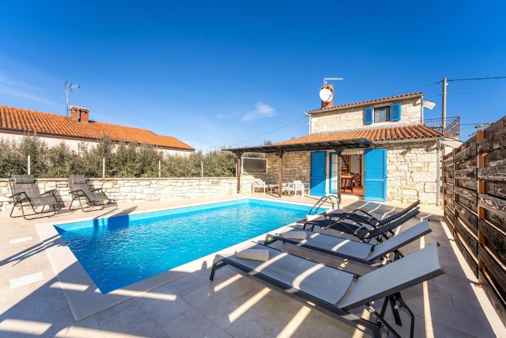 een villa met een zwembad en een huis bij Casa Nadalina in Višnjan