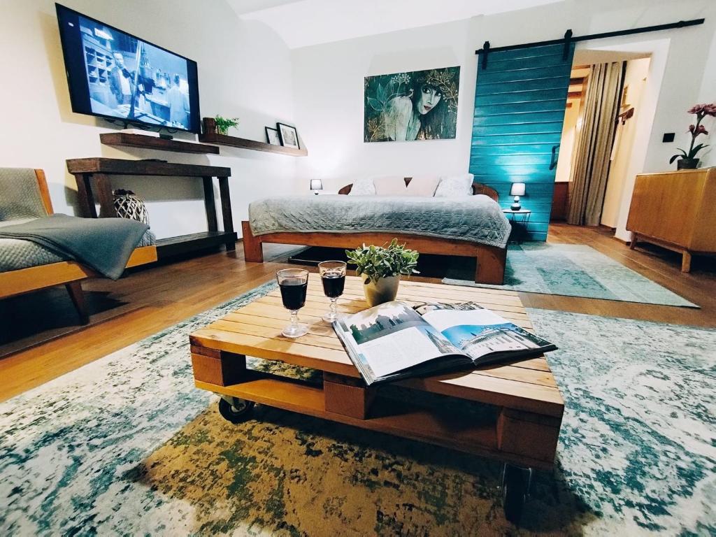 sala de estar con cama y mesa con copas de vino en Onefourfour Apartment, en Brandýs nad Labem-Stará Boleslav