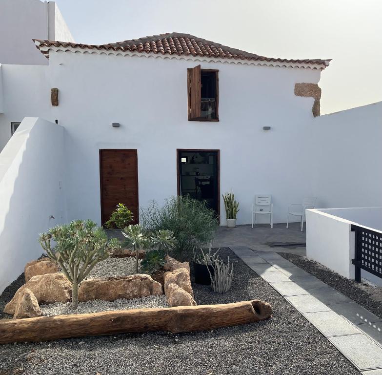 una casa blanca con un jardín delante de ella en Casa El granero de Antonio, en San Miguel de Abona