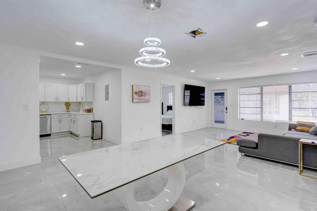una gran sala de estar blanca con sofá y mesa en 4 bedroom 3 bath villa, en Fort Lauderdale