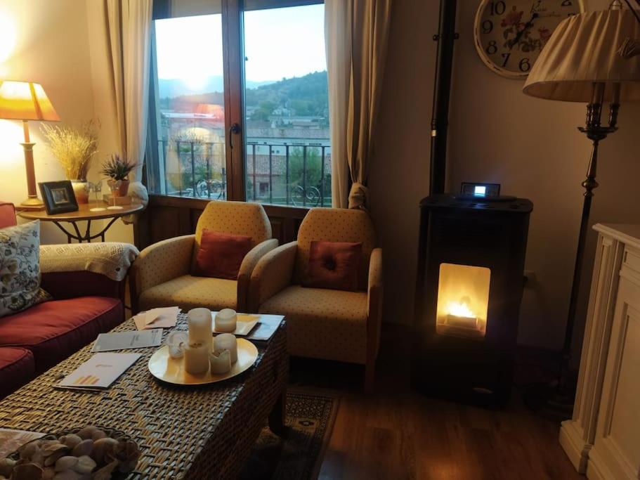 a living room with a fireplace and a table with candles at Apartamento Gandía, Orihuela del Tremedal. in Orihuela del Tremedal