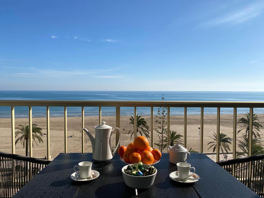 una mesa con un bol de fruta en el balcón con vistas a la playa en 1a línea con PISCINA Nuevo, en Cullera