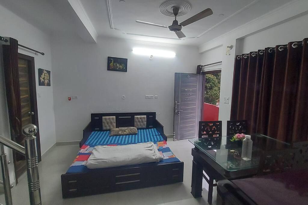 a bedroom with a bed and a table in it at Entire 1 BHK Cottage in Nainital