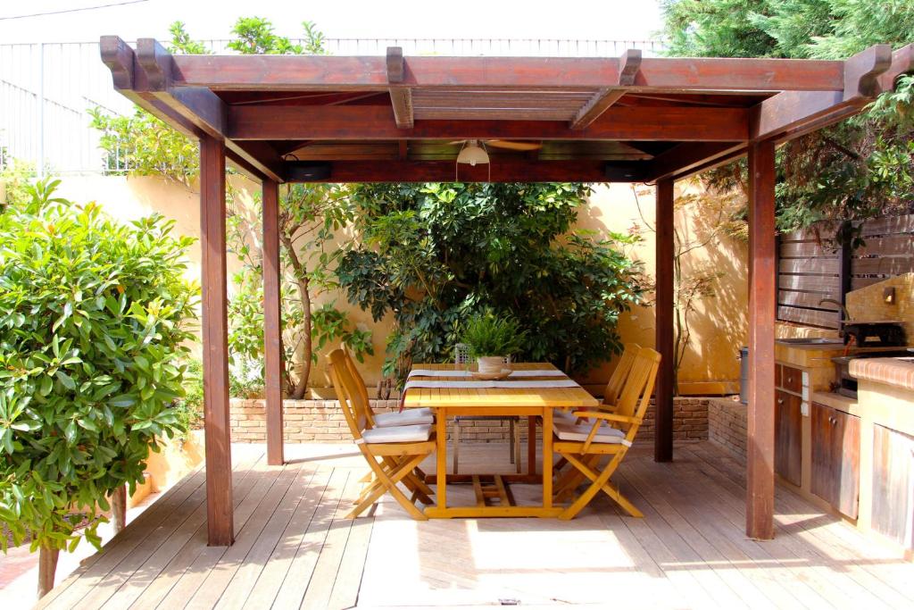 a wooden pergola with a table and chairs on a patio at Lida Garden Studio in Anavyssos
