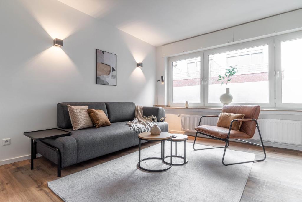 ein Wohnzimmer mit einem Sofa und einem Stuhl in der Unterkunft *MODERN & MINIMALISTIC* Design-Apartment I Stadtmitte in Wesel
