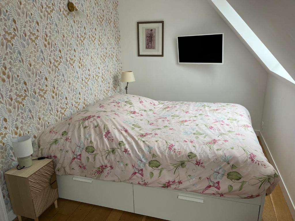 Dormitorio blanco con cama con colcha de flores en Chambre privée Place aux oignons en Lille