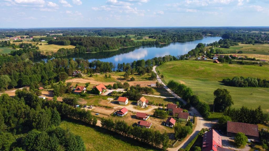 an aerial view of a village next to a river at Domki na Mazurach Kurka Wodna in Mikołajki