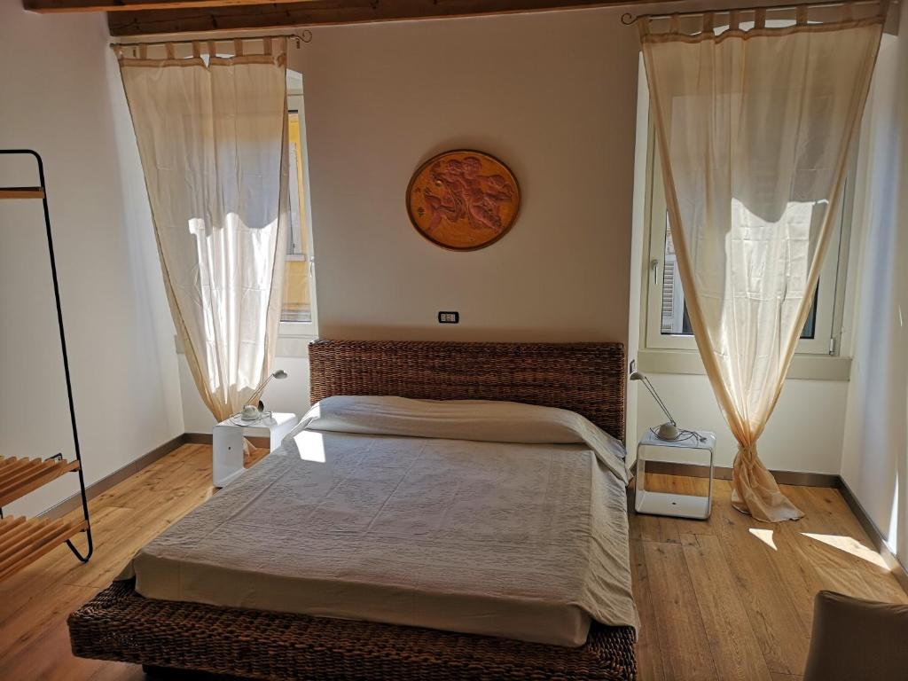 een slaapkamer met een bed met gordijnen en een klok aan de muur bij Appartamento in centro Bergamo in Bergamo