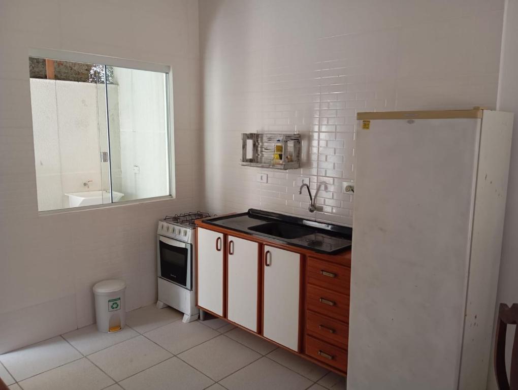 uma pequena cozinha com um lavatório e um fogão em Casa boa e barata em Guaratuba em Guaratuba