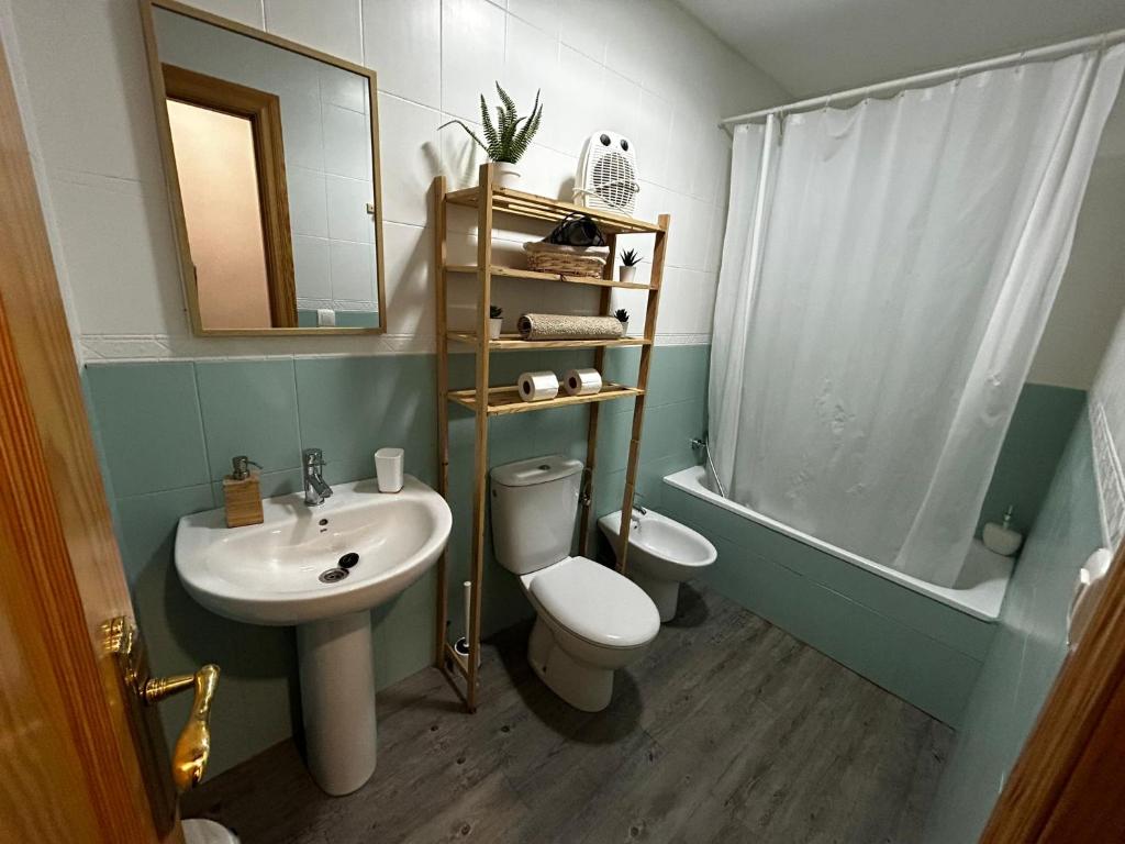 a bathroom with a sink and a toilet and a mirror at La fuente in Güéjar-Sierra