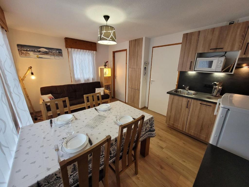 une cuisine et une salle à manger avec une table et des chaises dans l'établissement Appartement 4 pers rénové, lumineux, au centre des Gets, proche pistes et commerces - FR-1-598-114, aux Gets