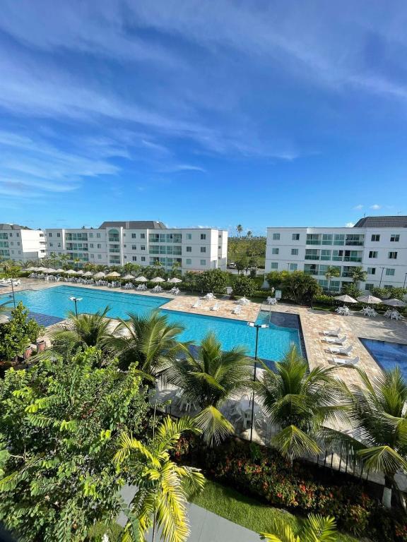 uma vista aérea de um resort com duas piscinas e palmeiras em Palm Village Família Flats 03 Qrts em Ipojuca